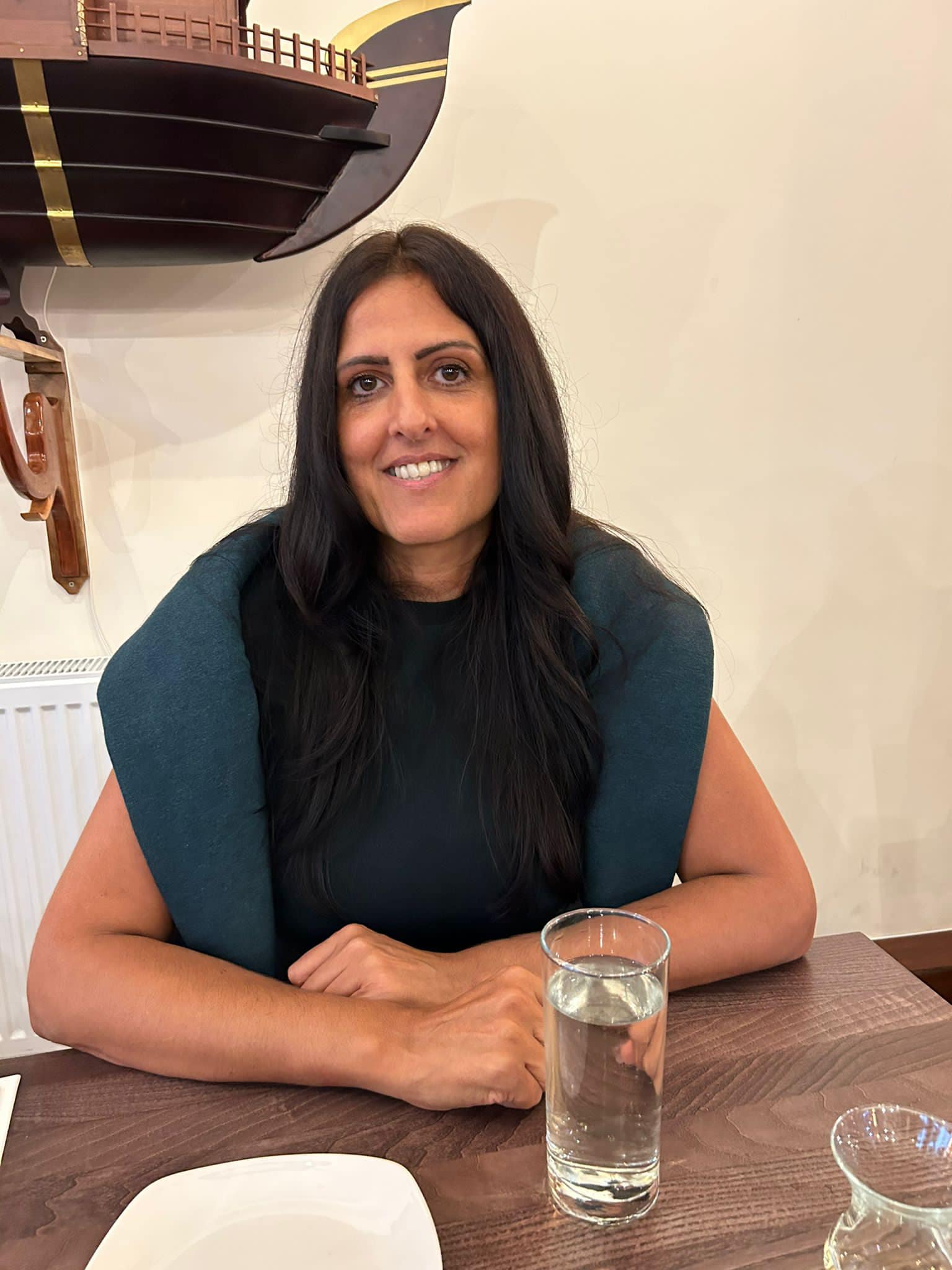 lady sitting at tale smiling with glass of water in front of her