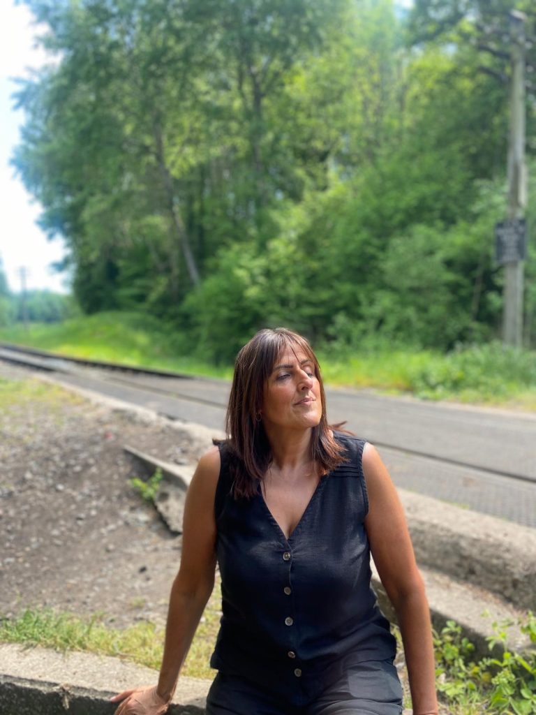 woman sitting on disused railway, meditating